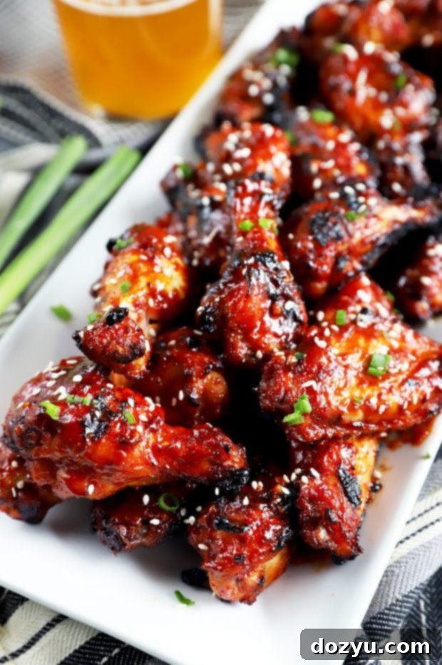 Sticky Crispy Korean BBQ Wings 2 Crispy Korean BBQ chicken wings on a plate with green onion garnish