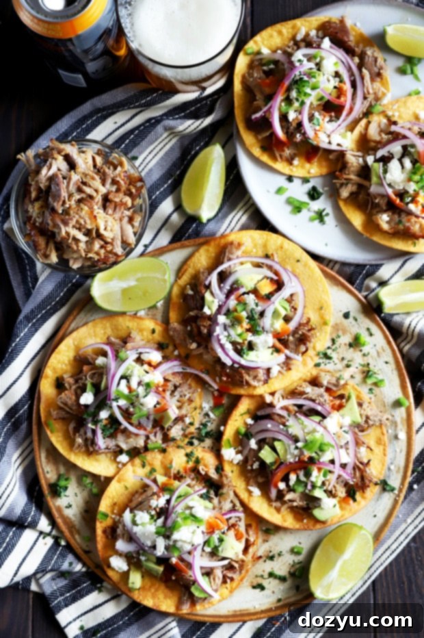 Overhead photo of three beautifully arranged crispy pork carnitas tostadas, garnished with fresh toppings.