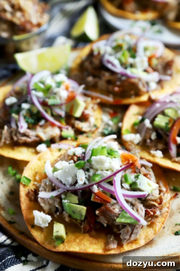 Instant Pot Carnitas piled high on two tostada shells, ready to be enjoyed.
