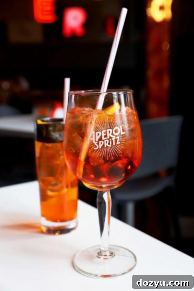 A vibrant Aperol Spritz cocktail at Terrazza Aperol in Milan overlooking the Duomo