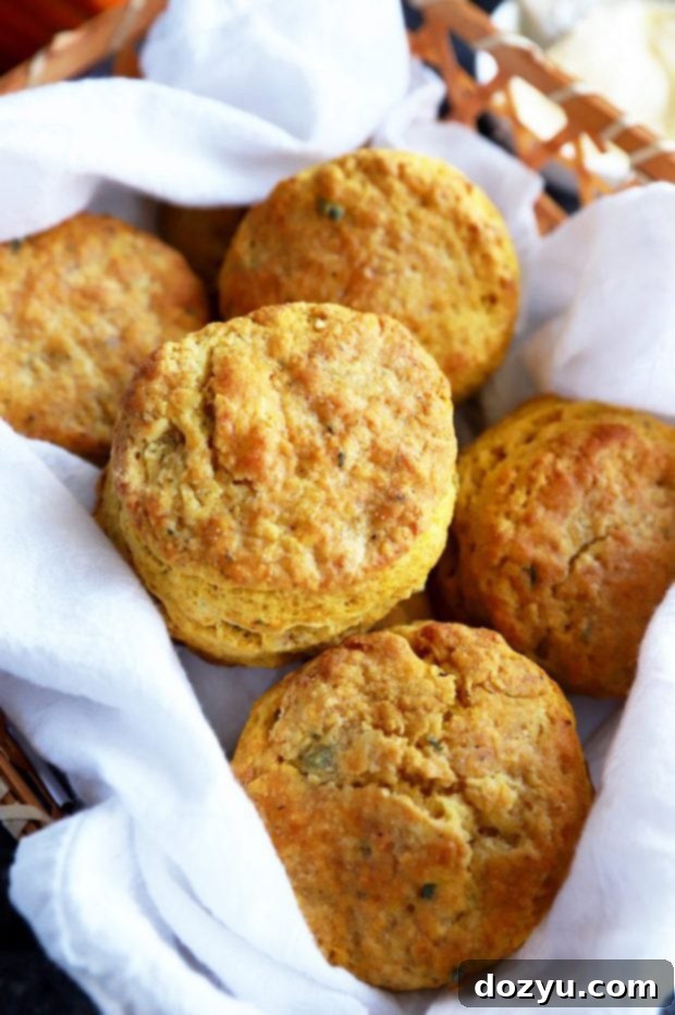 A charming basket overflowing with warm, golden pumpkin sage biscuits, invitingly ready to be served and enjoyed.