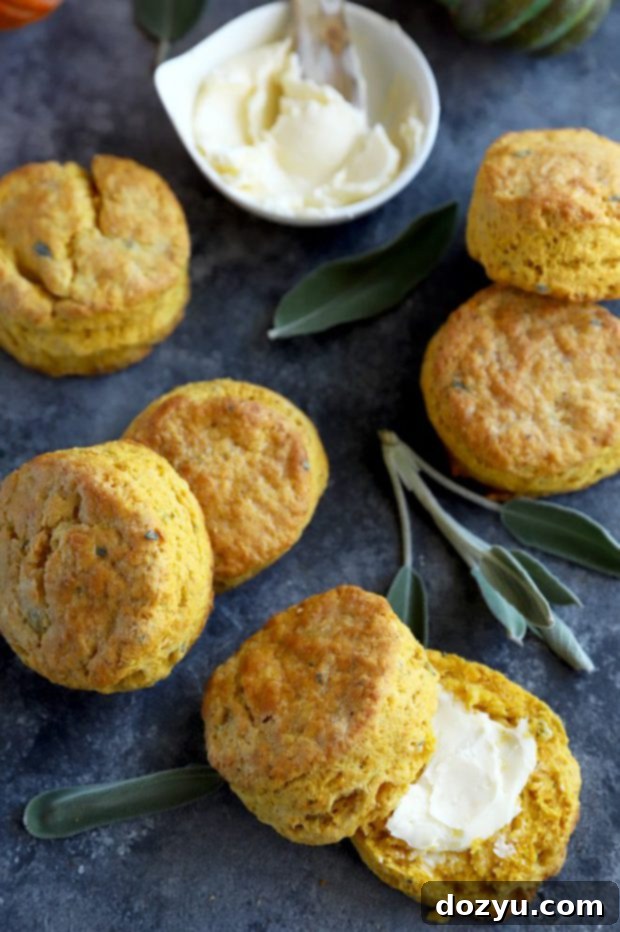 An overhead view of warm pumpkin sage biscuits next to a small dish of melting butter, invitingly arranged for serving.