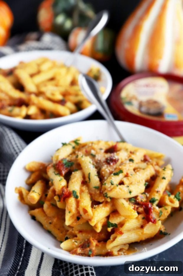 Garlic-Roasted Pumpkin Hummus Pasta 2 Pasta in white bowls for an easy dinner, garnished with fresh parsley.