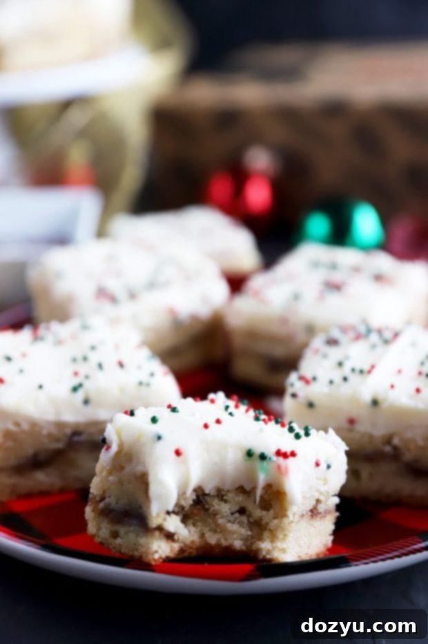 Spiced Snickerdoodle Eggnog Bars 5 Bite taken out of a frosted snickerdoodle cookie bar on a festive plate
