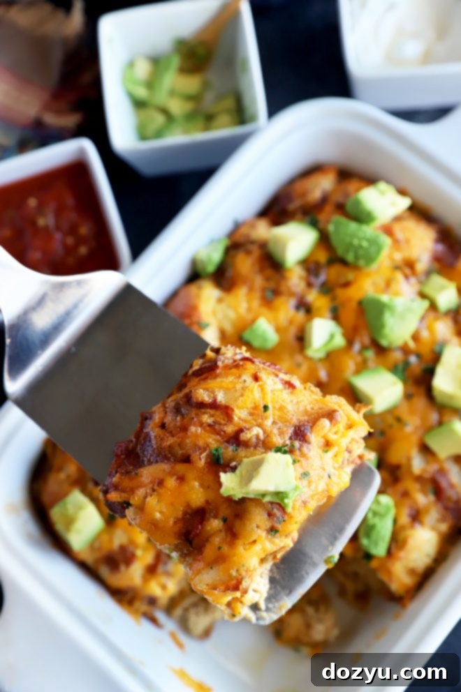A spatula lifting a perfectly baked slice of Mexican Bacon, Egg & Cheese Biscuit Bake, showing the crispy edges and soft interior.