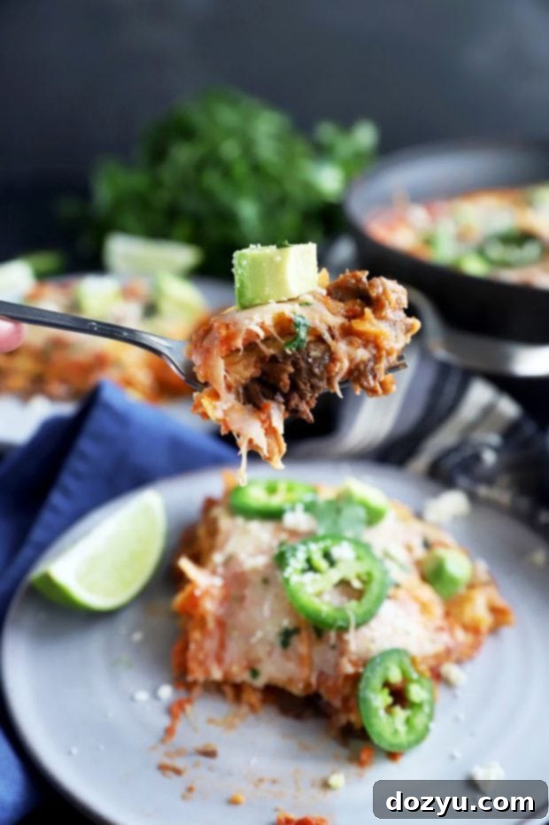 Close-up shot of a fork taking a bite from the Short Rib Mexican Skillet Pie, showing the tender short ribs and melted cheese.