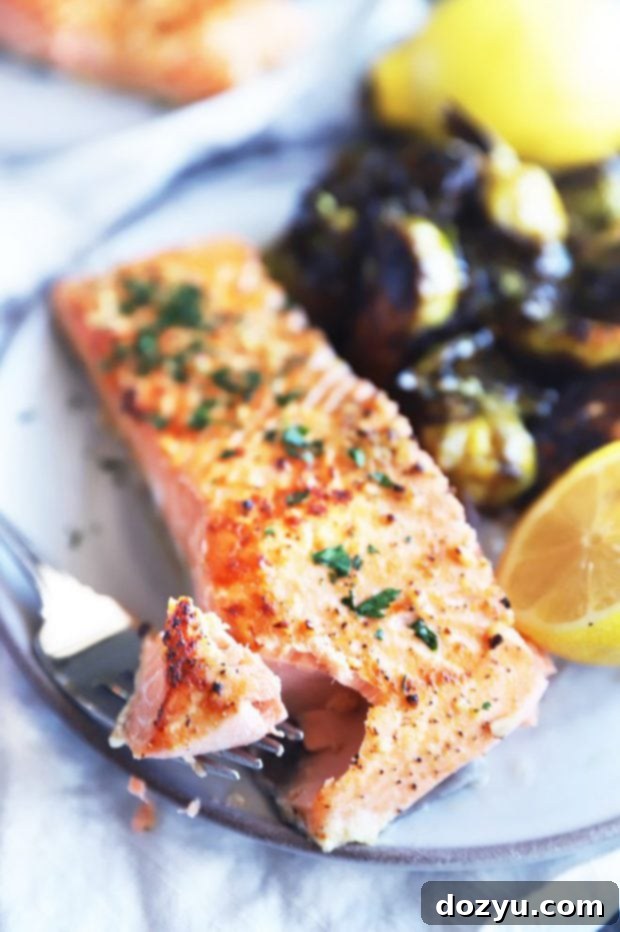 Zesty Lemon Garlic Salmon Bake 3 Fork taking a bite of baked salmon