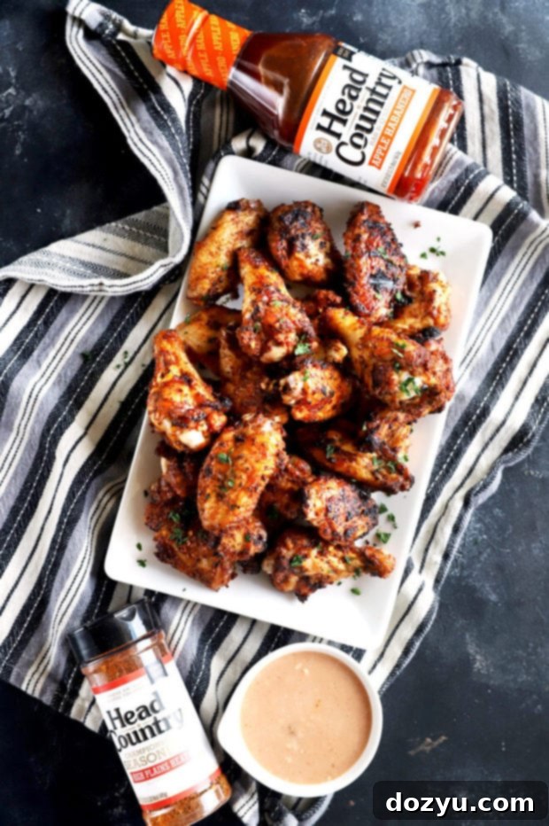 Smoky Dry-Rubbed Wings with Zesty BBQ Blue Cheese 4 Overhead photo of a platter of dry rub chicken wings with a bottle of Head Country Bar-B-Q sauce