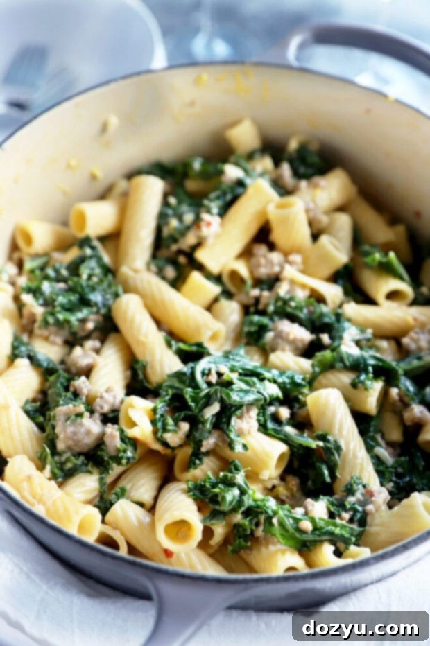 Rich Creamy Sausage Kale Rigatoni 7 Creamy sausage kale rigatoni pasta mixed in a Dutch oven, steaming hot and ready to be served.