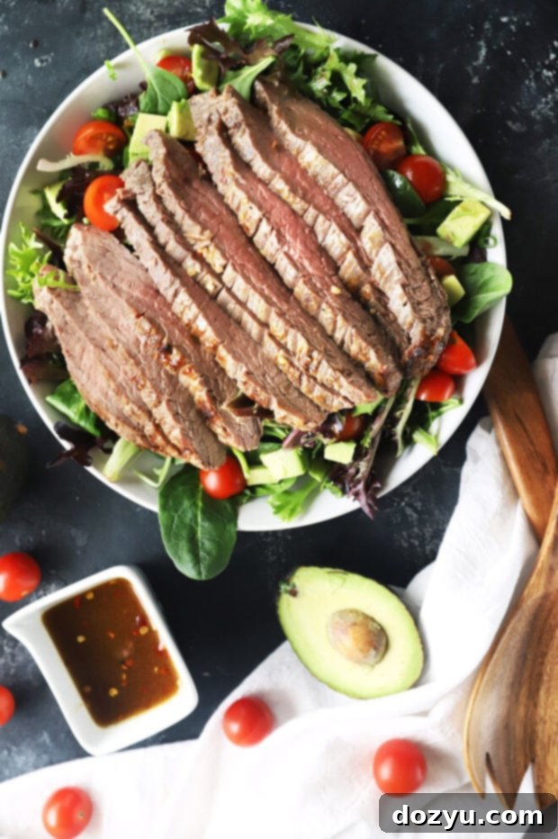 Umami Steak & Avocado Power Bowl 4 Close-up of miso marinated steak salad with the dressing being poured over, highlighting the rich colors
