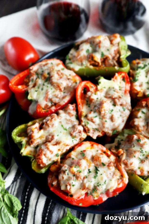 Bold Italian Stuffed Peppers 6 Side view of two colorful Italian stuffed peppers on a plate, garnished with fresh basil.