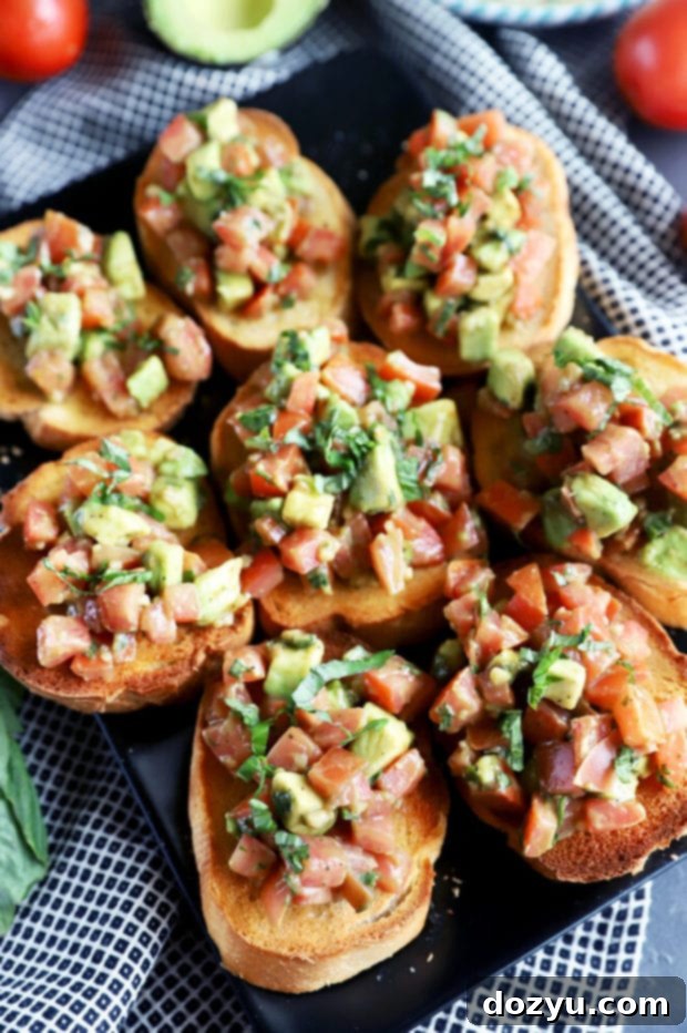 Close-up photo of easy avocado bruschetta on a white plate, highlighting texture