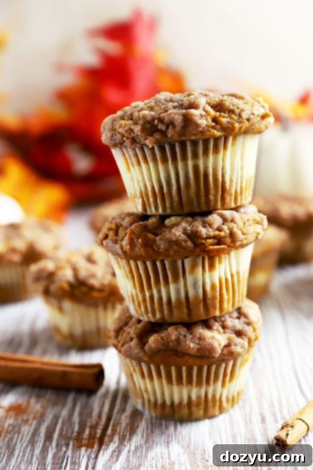 Cream Cheese Swirl Pumpkin Crumble Muffins 3 Stack of freshly baked pumpkin cream cheese muffins with a perfect streusel topping