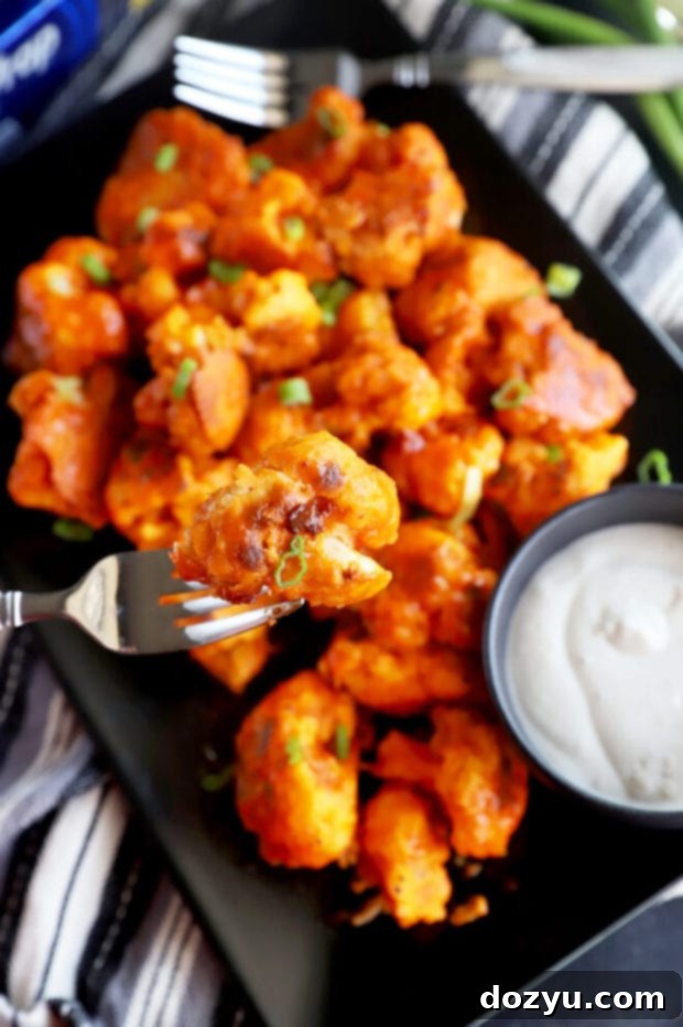 Golden Crispy Buffalo Cauliflower Wings 5 Fork holding a piece of baked cauliflower picture