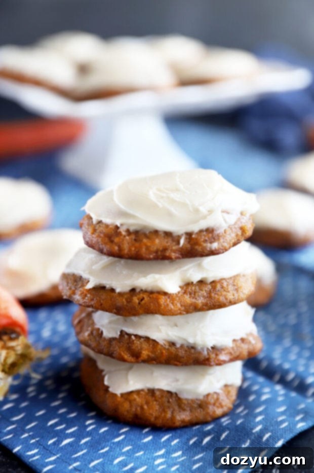 Spiced Carrot Cake Cookies 2 Stacked chewy carrot cake cookies with fluffy cream cheese frosting