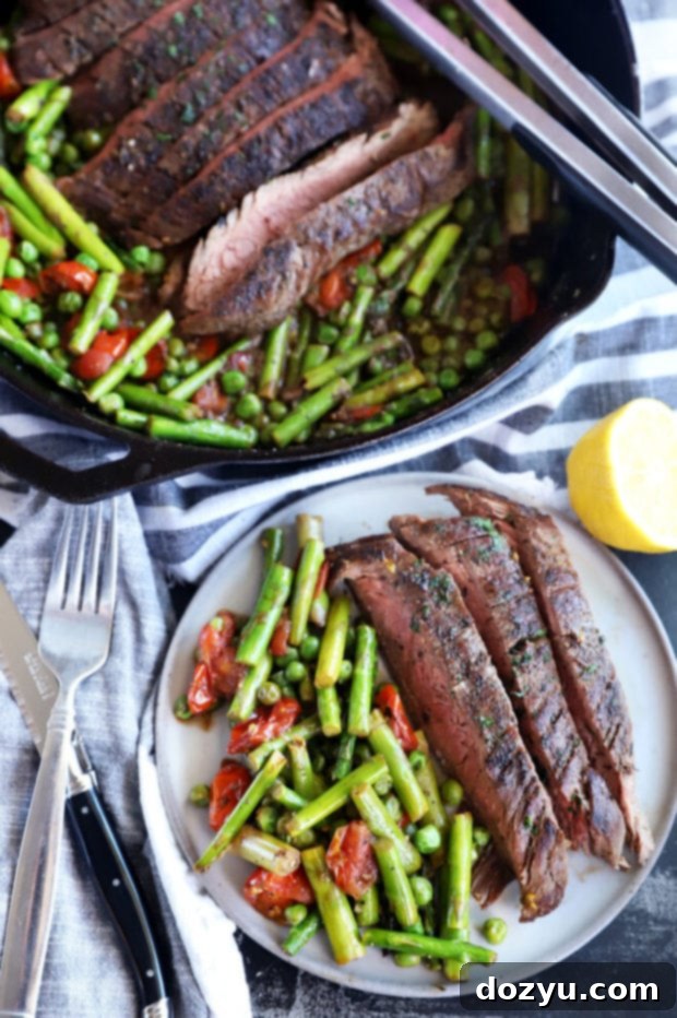 Overhead photo of a plated one-pan steak and spring vegetables with a glass of wine