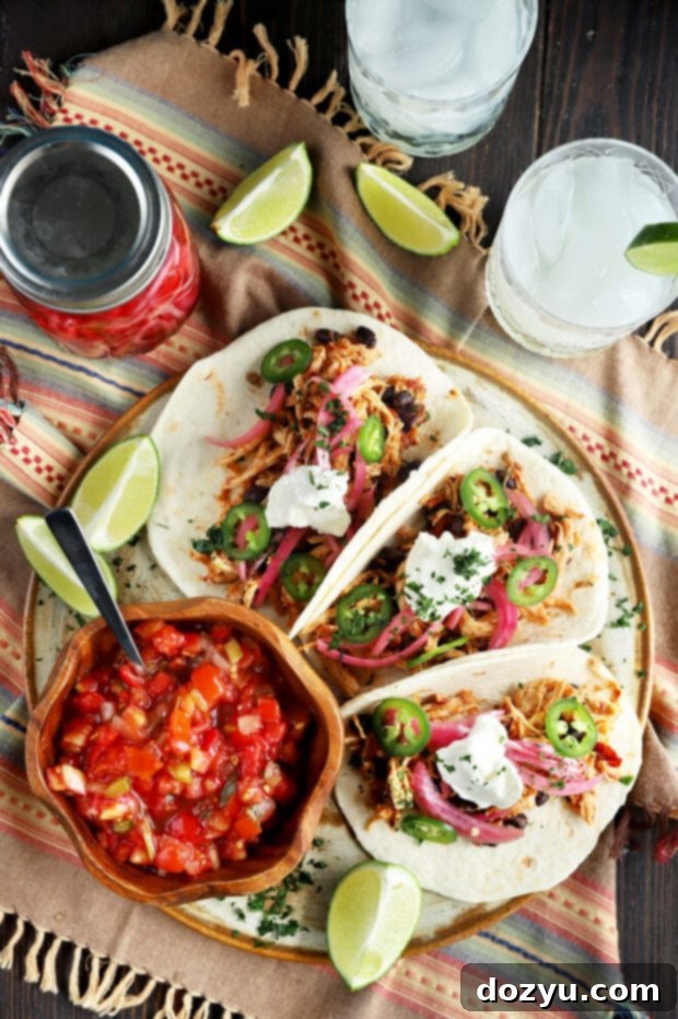 Speedy Instant Pot Chipotle Chicken Tacos 3 Overhead view of several Instant Pot chipotle chicken tacos with diverse toppings