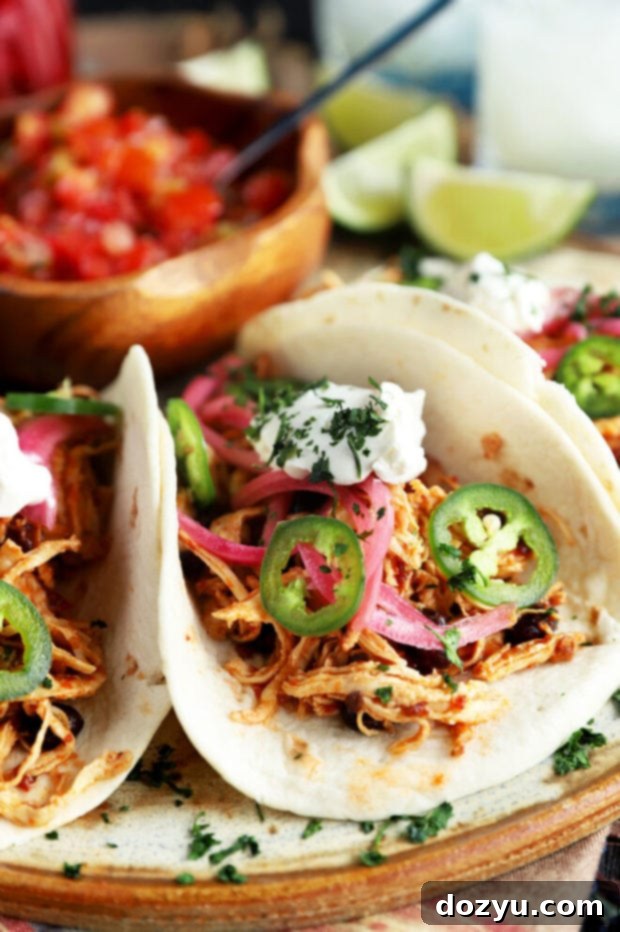 Speedy Instant Pot Chipotle Chicken Tacos 6 Instant Pot chipotle chicken tacos arranged in warm tortillas with various fresh toppings