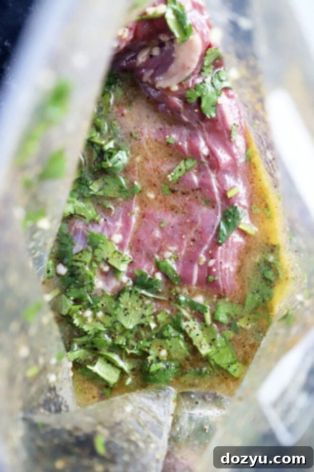 Mojo steak in marinade photo, showing the beef soaking up flavors