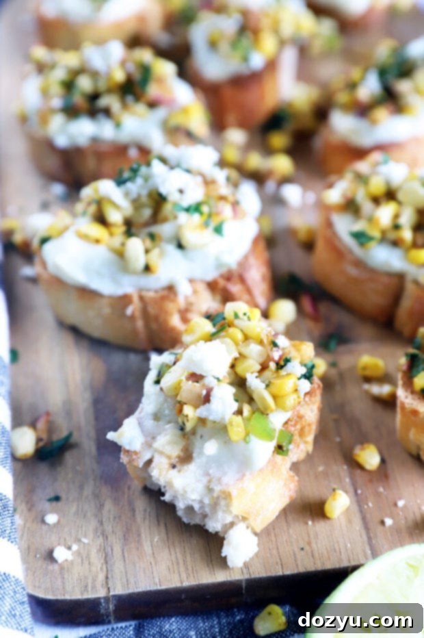 Zesty Grilled Elote Crostini 6 Close-up of a crostini with a bite taken out, showing the layered textures