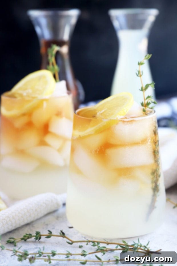 The Sparkling Arnold Palmer 2 A tall glass of sparkling Arnold Palmer with lemon slices and ice, perfect for summer refreshment.