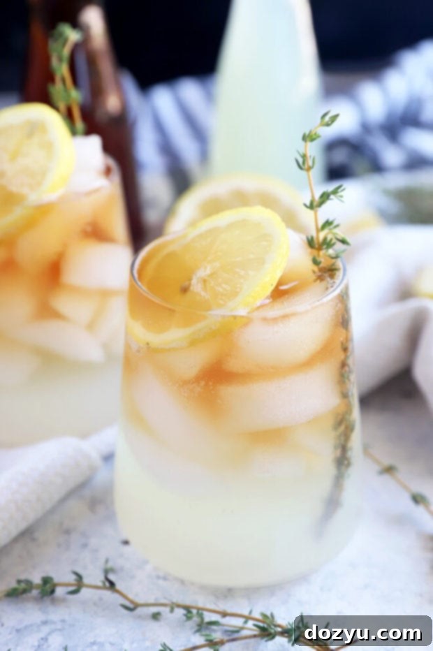 The Sparkling Arnold Palmer 4 A refreshing Arnold Palmer in a tall glass with a lemon slice and ice, sitting on a wooden surface.