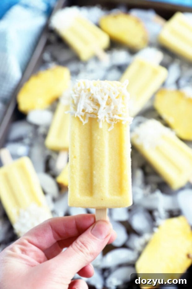 Tropical Pina Colada Popsicles 6 Hand holding pineapple coconut popsicle picture, close-up showing the inviting texture