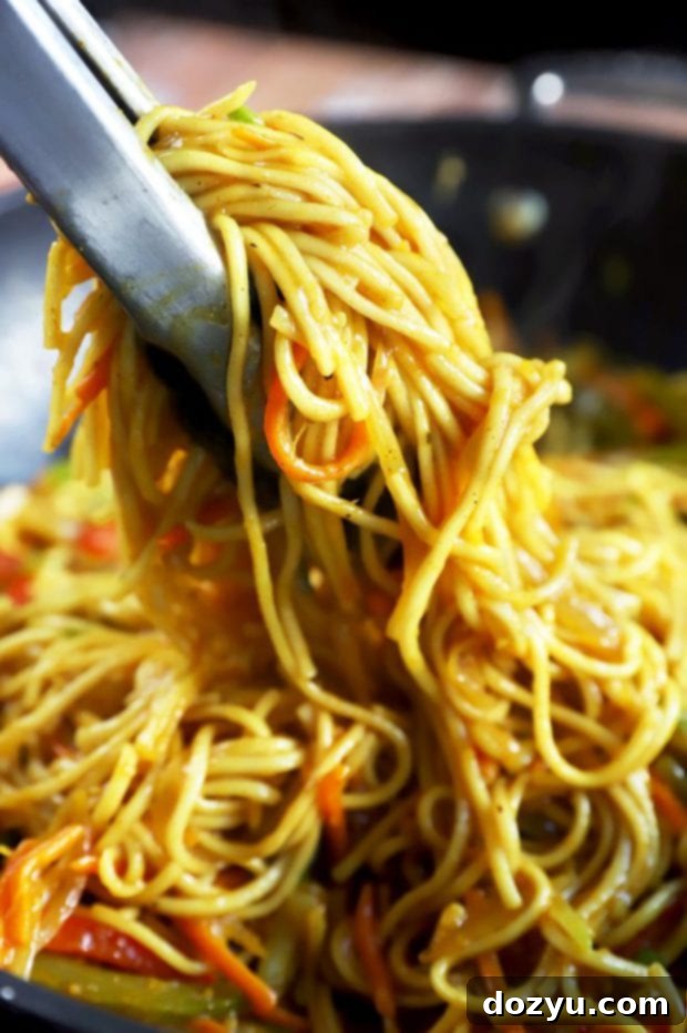 Sizzling Singapore Noodles 7 Tongs holding Asian noodles picture
