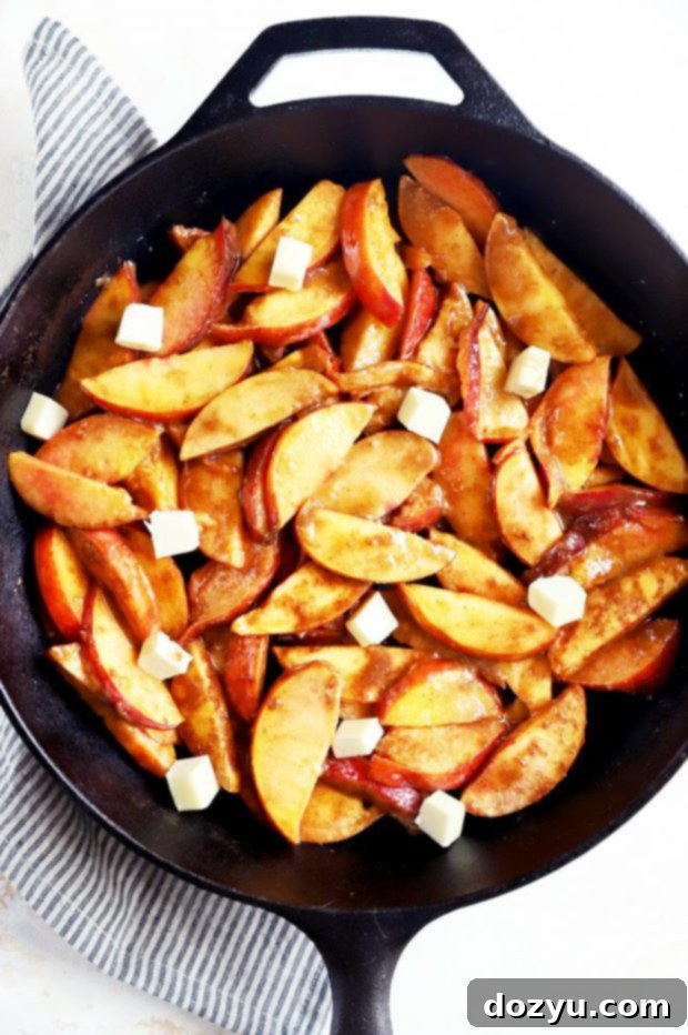 Flame-Kissed Peach Cobbler 5 Fresh peaches with sugar and butter in a skillet image