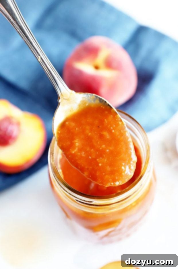 Bourbon Peach BBQ Bliss 4 Spoon lifting homemade peach bbq sauce from a pan
