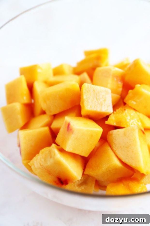 Bourbon Peach BBQ Bliss 5 Peeled and chopped fresh peaches in a bowl, ready for Bourbon Peach BBQ Sauce