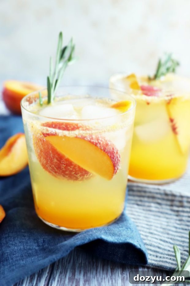 Two glasses of Sparkling Rosemary Peach Mocktails on a table, ready to be served, highlighting their vibrant colors.