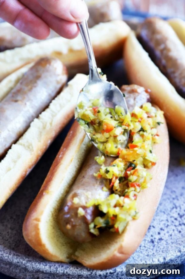 Zesty Pepperoncini Relish 8 Putting relish on bratwurst image with ketchup and mustard