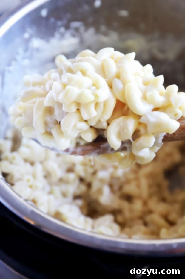 Instant Pot Creamy White Cheddar Mac and Cheese 7 Spoon lifting out mac and cheese picture