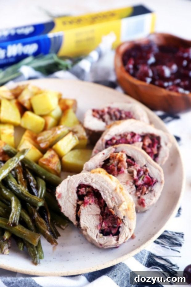 Festive Sheet Pan Stuffed Pork Tenderloin 7 Image of sliced stuffed pork on a plate