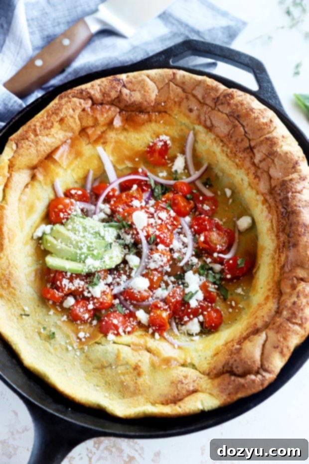 Puffed Savory Pancake 3 Overhead view of a Dutch baby in a skillet, showcasing its puffed edges and golden color