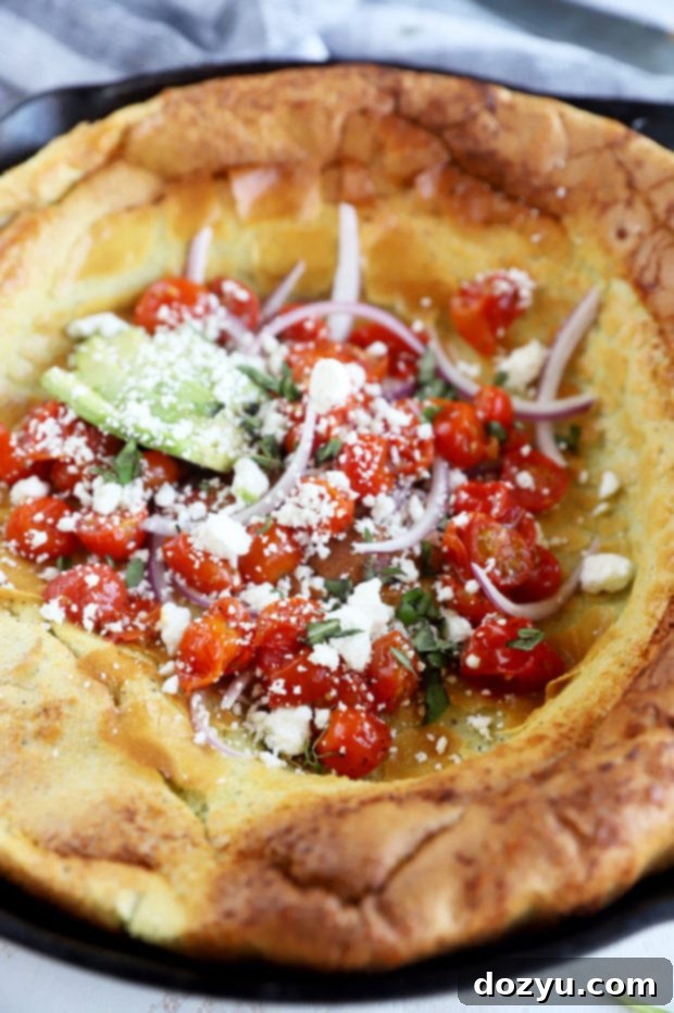 Puffed Savory Pancake 7 Side view of the savory Dutch Baby, showcasing its height and layers of toppings