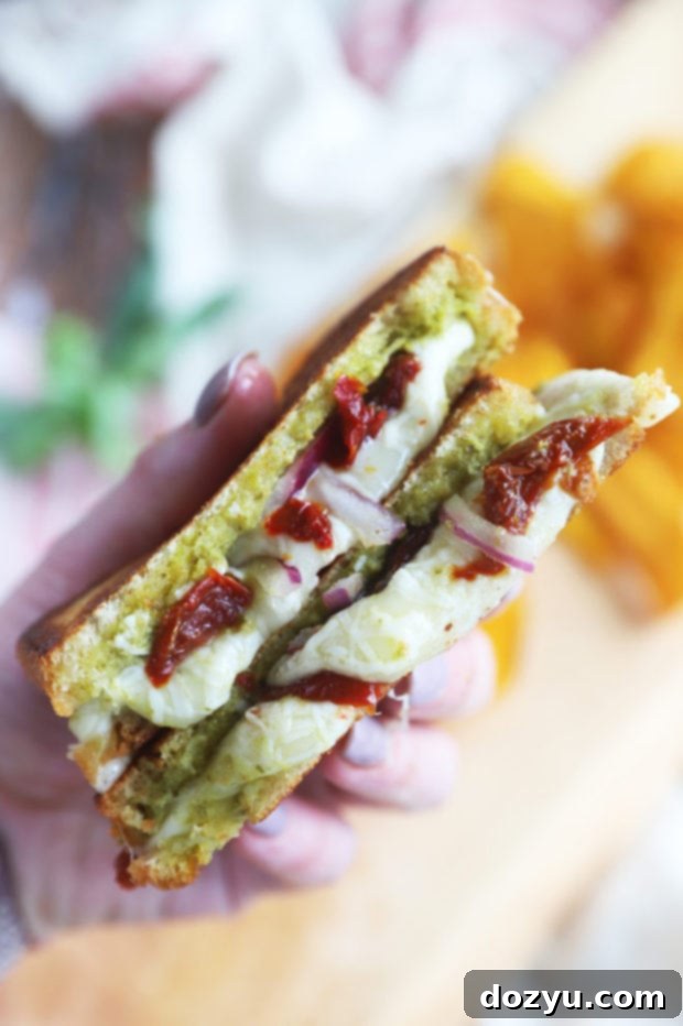Pesto Grilled Cheese: Two Irresistible Twists 8 Hand holding grilled cheese image