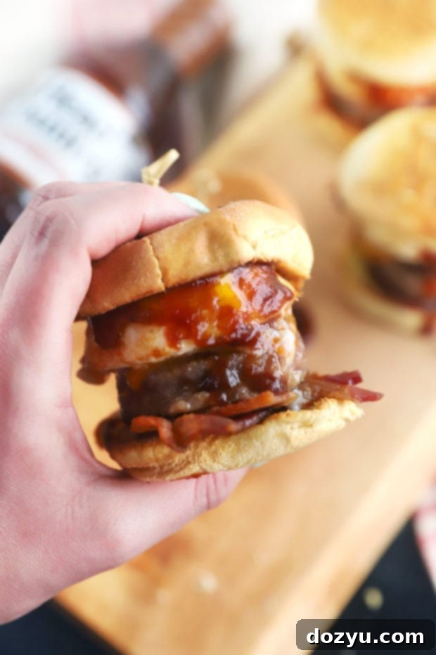 Cheesy BBQ Breakfast Pull-Aparts 3 Hand holding a savory BBQ breakfast slider with bacon, egg, and cheese