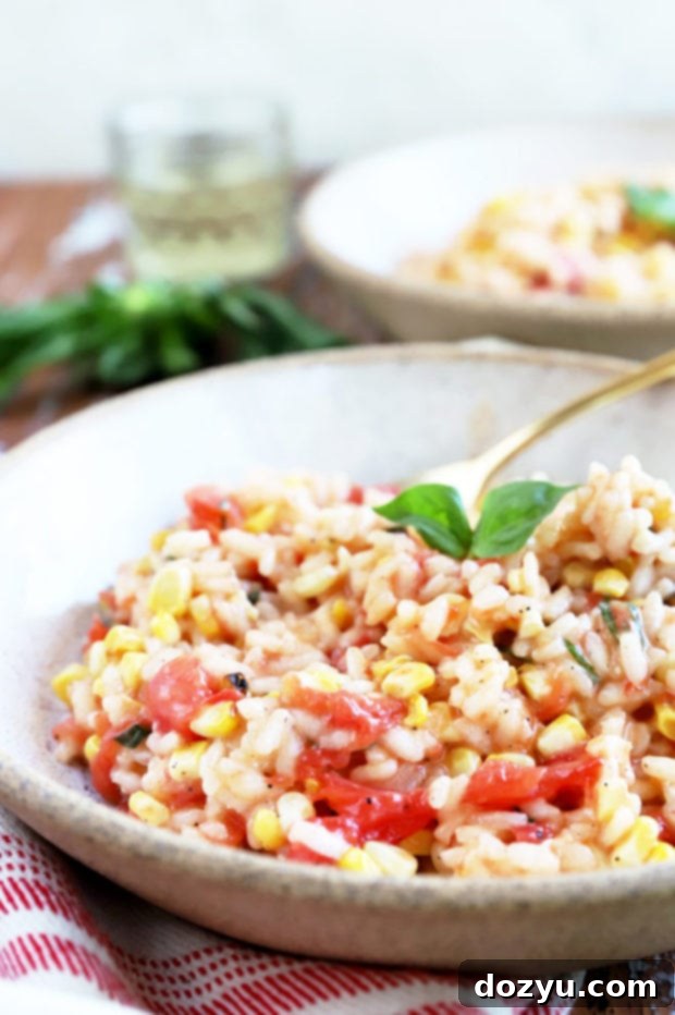 Sunkissed Corn and Tomato Risotto 3 Close-up side view of creamy risotto showcasing bright red tomatoes and yellow corn kernels.