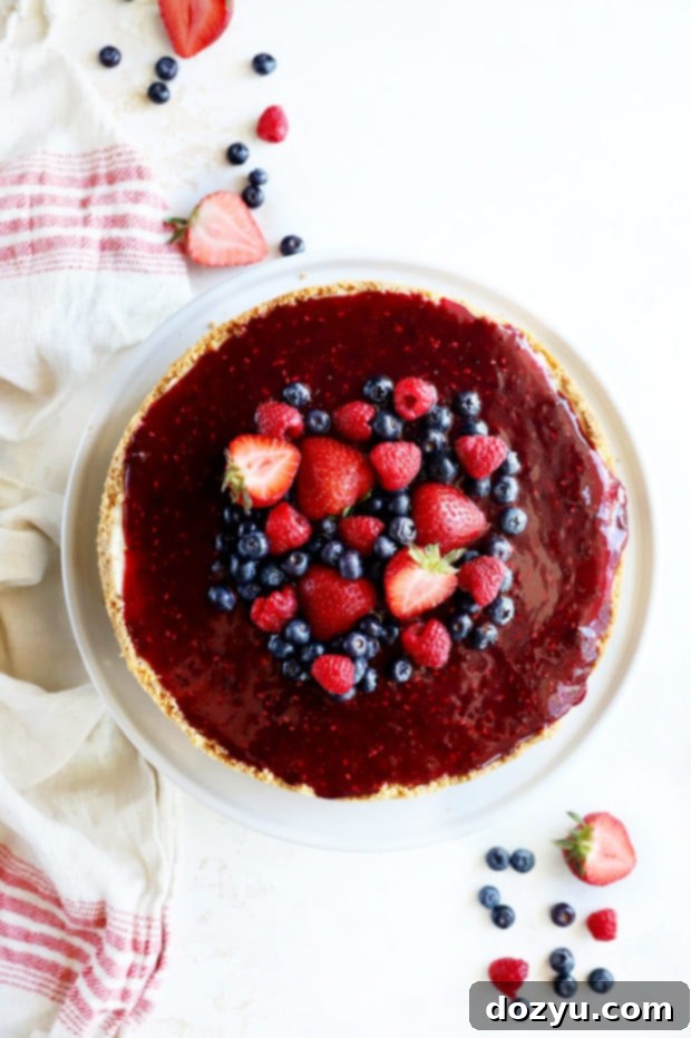 Berry Medley Cheesecake 2 Overhead photo of a beautifully decorated Triple Berry Cheesecake with fresh raspberries, strawberries, and blueberries.