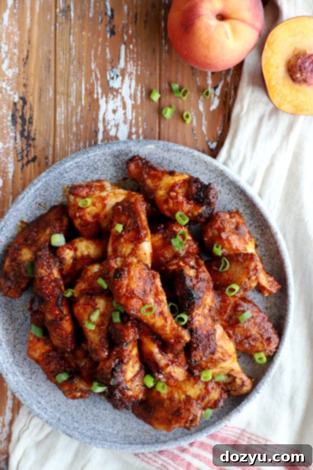 Sticky Bourbon Peach BBQ Wings 2 Overhead image of sticky Bourbon Peach Grilled BBQ Wings on a platter, garnished with fresh herbs