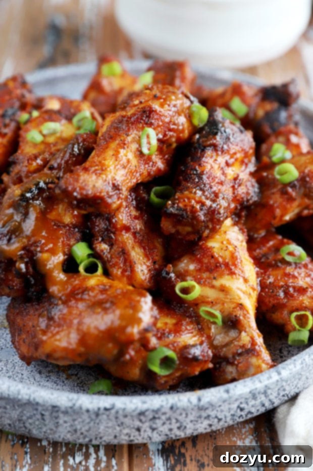 Sticky Bourbon Peach BBQ Wings 3 Side view of juicy peach BBQ grilled chicken wings, glistening with sauce