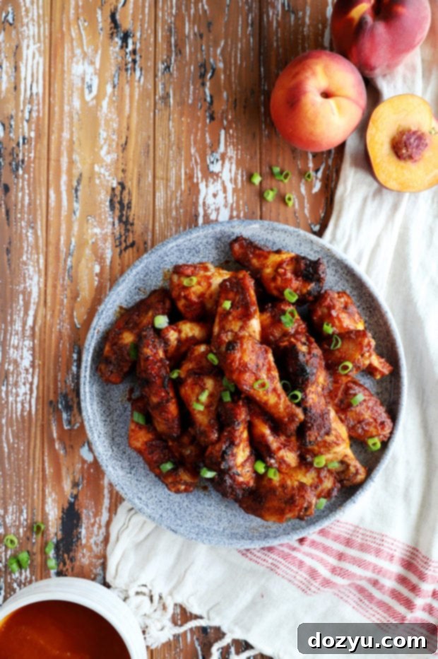 Sticky Bourbon Peach BBQ Wings 5 A vibrant platter of peach bourbon chicken wings, beautifully arranged and garnished