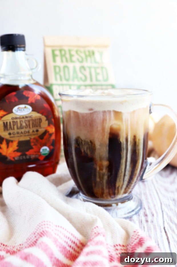 Maple Sweet Cream Cold Brew 4 Side view of a Maple Sweet Cream Cold Brew, showing the distinct layers of coffee and cream, garnished with cinnamon.