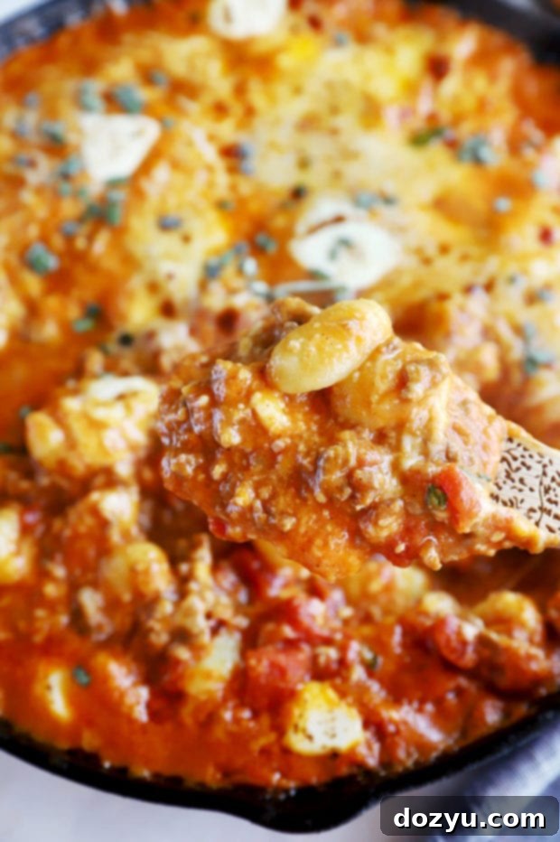 Golden Pumpkin Gnocchi Gratin 7 Spooning out pumpkin gnocchi bake image