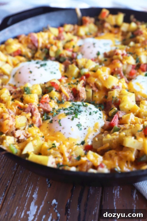Side photo of Southwestern Ham Hash in a skillet with a spoon, showing its hearty texture.