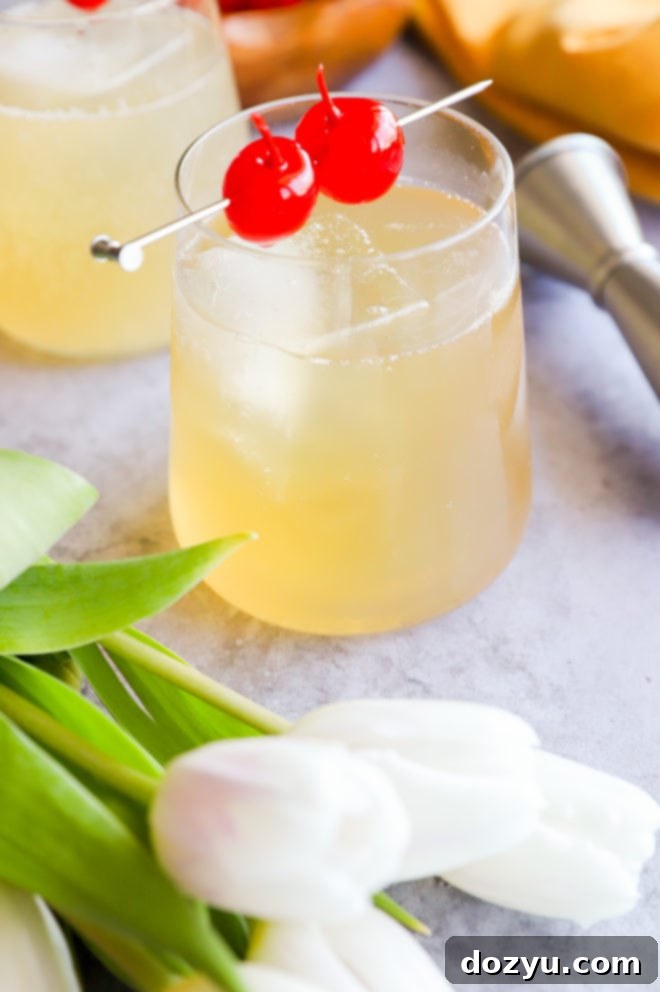 Sparkling Whiskey Sour 6 A sparkling whiskey sour cocktail with a lemon slice garnish, set amidst delicate white tulips, conveying a fresh and elegant drinking experience.