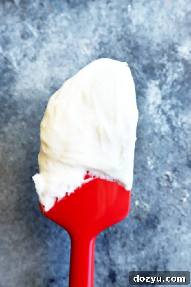 Sparkling Champagne Cream Cheese Frosting 3 Spatula coated with creamy champagne cream cheese frosting