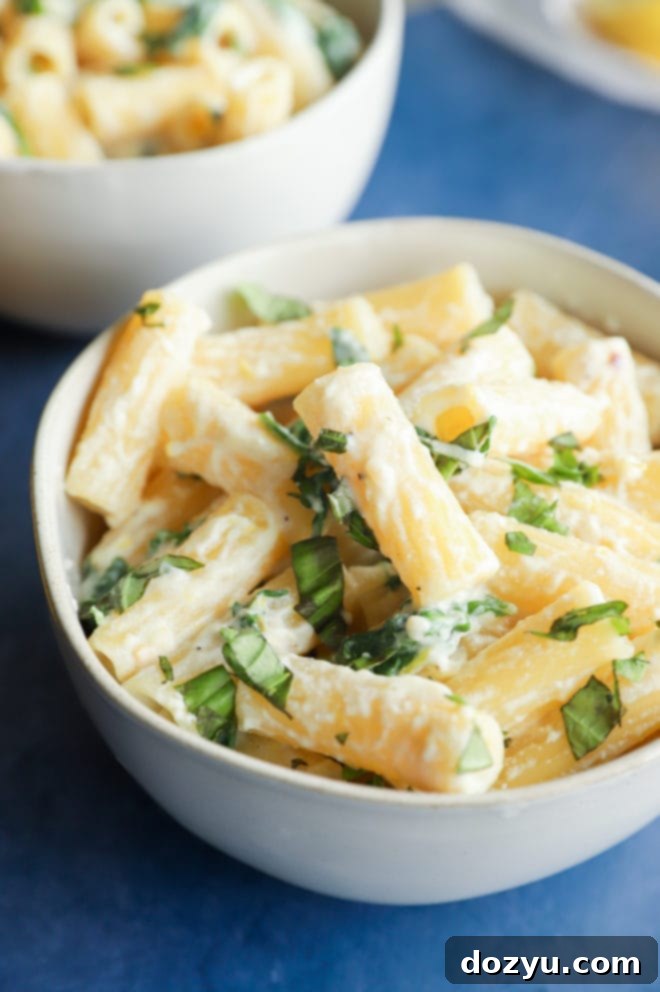 Lemony Cloud Pasta 2 Side photo of creamy lemon ricotta pasta in a bowl with grated cheese and fresh arugula